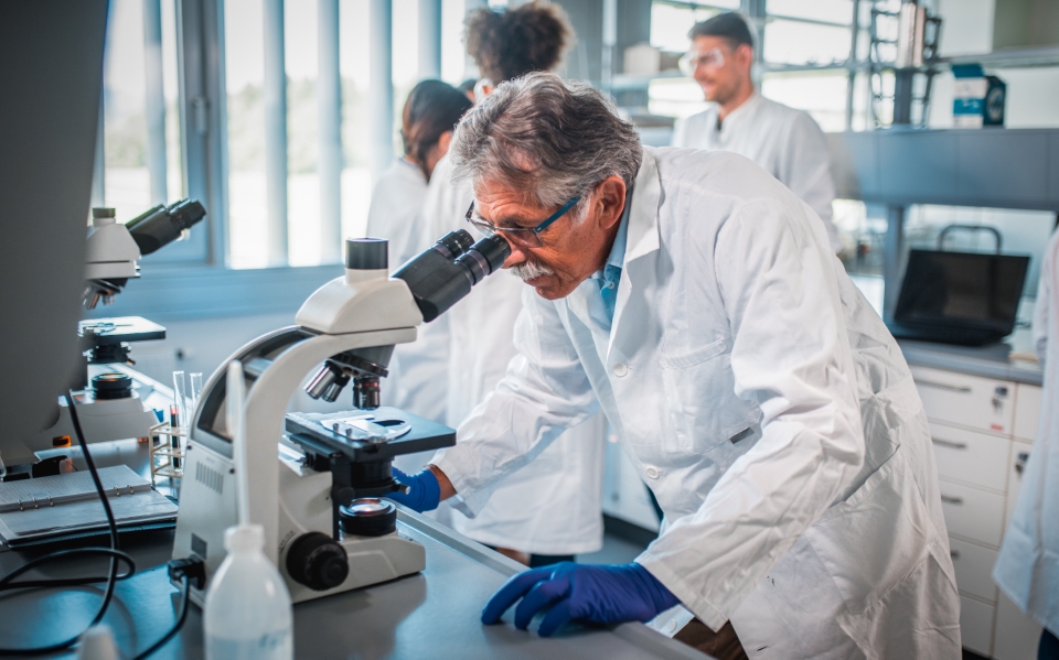 Scientist using microscope in laboratory.